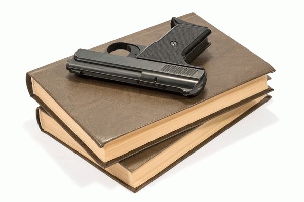 пистолет лежит на книгах